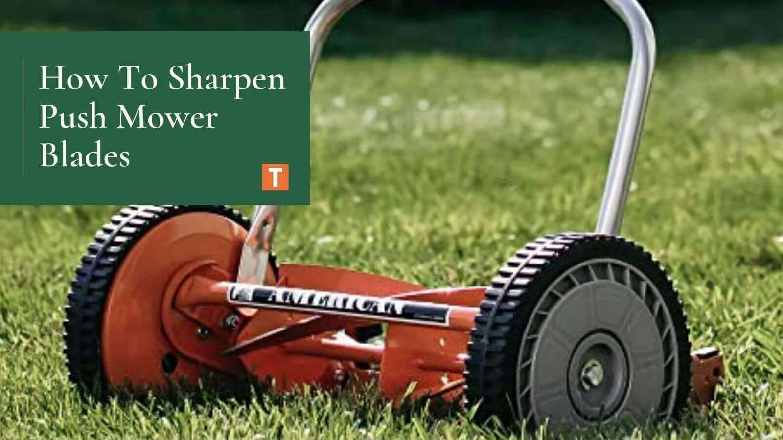 Red reel lawn mower on grass