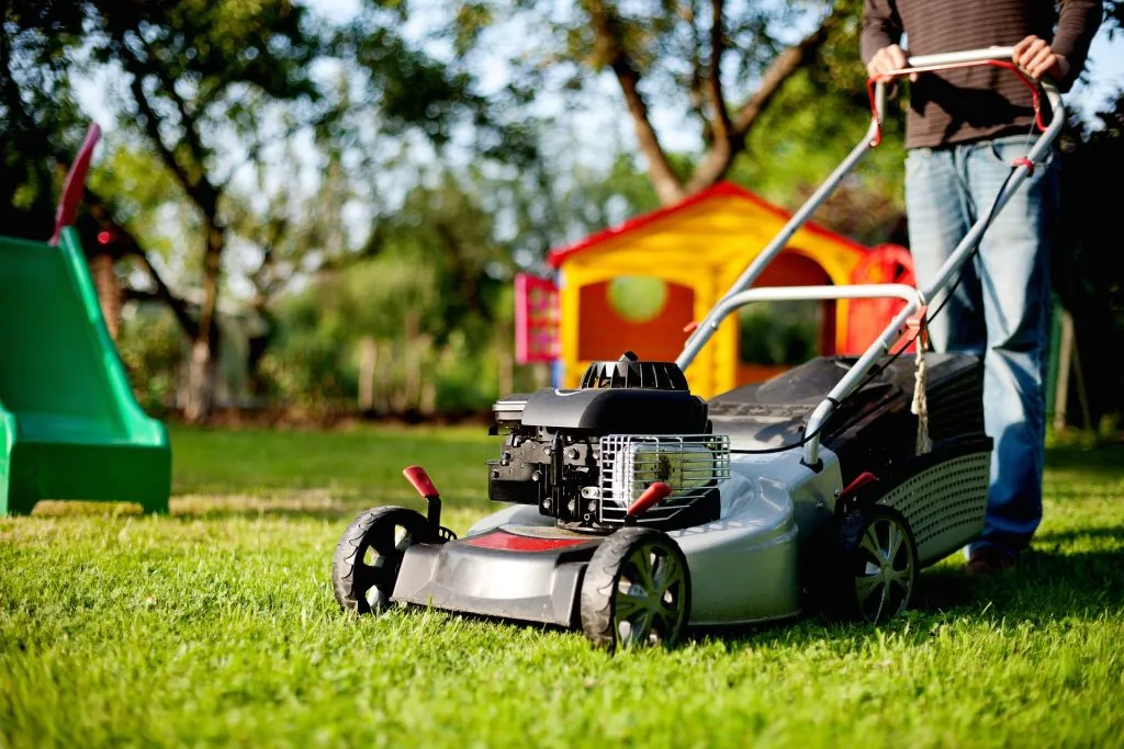 Lawn mower being pushed across grass